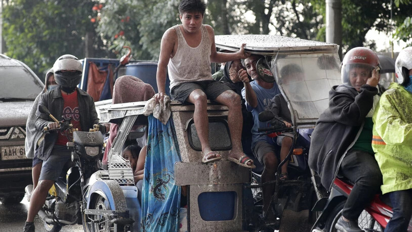 Menschen bringen sich vor dem Vulkan Taal auf den Philippinen in Sicherheit.