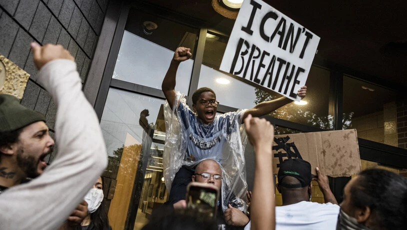 Demonstranten versammeln sich auf einem Polizeirevier und fordern mit einem Plakat mit der Aufschrift "I can't breathe" (dt. Ich kann nicht atmen) Gerechtigkeit für einen Mann afroamerikanischer Abstammung, der nach der Festnahme durch die Polizei…