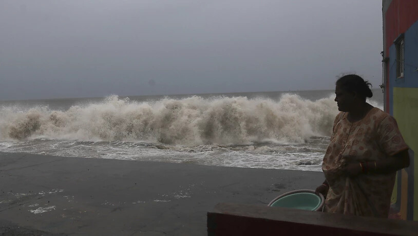 Eine Frau beobachtet im indischen Mumbai die Wellen am Ufer des Arabischen Meeres. Foto: Rafiq Maqbool/AP/dpa