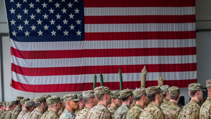 ARCHIV - US-Soldaten stehen während einer militärischen Zeremonie in Bayern vor einer Flagge der Vereinigten Staaten von Amerika. Foto: Nicolas Armer/dpa