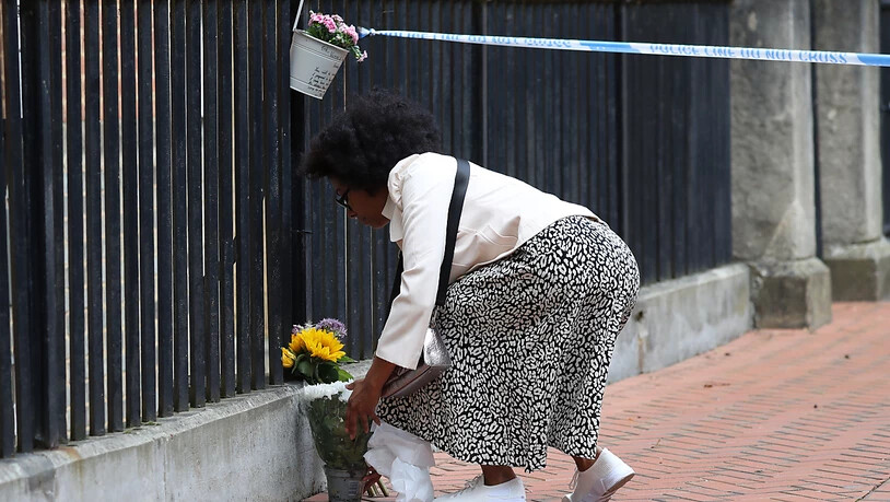 Eine Frau legt im Stadtzentrum von Reading Blumen nieder. Foto: Jonathan Brady/PA Wire/dpa