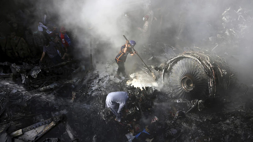 dpatopbilder - ARCHIV - In Karachi suchen freiwillige Helfer und Einsatzkräfte nach dem Absturz eines Passagierflugzeugs in einem Wohngebiet nach Überlebenden. Foto: Fareed Khan/AP/dpa