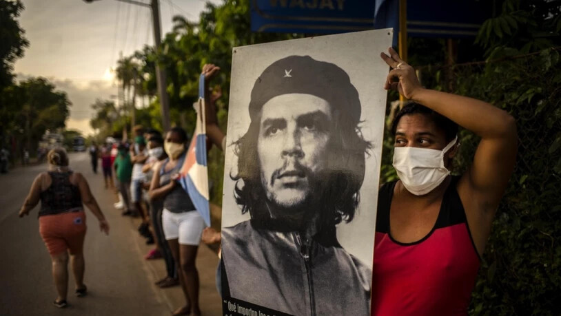 Frau in Havanna wartet während der Corona-Krise auf die Mediziner-Brigade des Henry Reeve Contingent und hält dazu das ikonische Foto "Guerillero Heroico" von Che Guevara hoch, das offenbar für jeden Anlass passt. Die Wohnung, in der Che geboren wurde,…