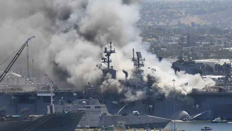 dpatopbilder - Rauch steigt vom US-Kriegsschiff «USS Bonhomme Richard» im Marinestützpunkt San Diego auf. Bei einem Feuer auf dem US-Kriegsschiff «Bonhomme Richard» in San Diego sind nach Angaben der Marine mehrere Soldaten leicht verletzt worden. Foto:…
