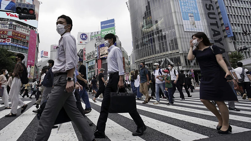 Passanten überqueren eine Straße in dem Stadtbezirk Shibuya. Japans Hauptstadt bestätigte am 31. Juli einen Zuwachs an mehr als 400 Corona-Neuinfektionen. Foto: Eugene Hoshiko/AP/dpa