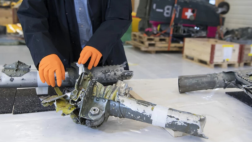 Ein Mitarbeiter der Sicherheitsuntersuchungsstelle (Sust) des Bundes schaut sich Wrackteile des in Graubünden 2018 abgestürzten Oldtimerfliegers Junkers Ju 52 an. (Archivbild)