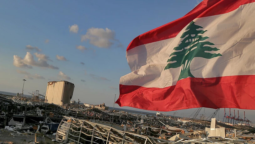 Eine libanesische Flagge weht in der Nähe der Stelle, an der eine Explosion am 4. August 2020 den Hafen von Beirut in die Luft sprengte. Foto: Marwan Naamani/dpa