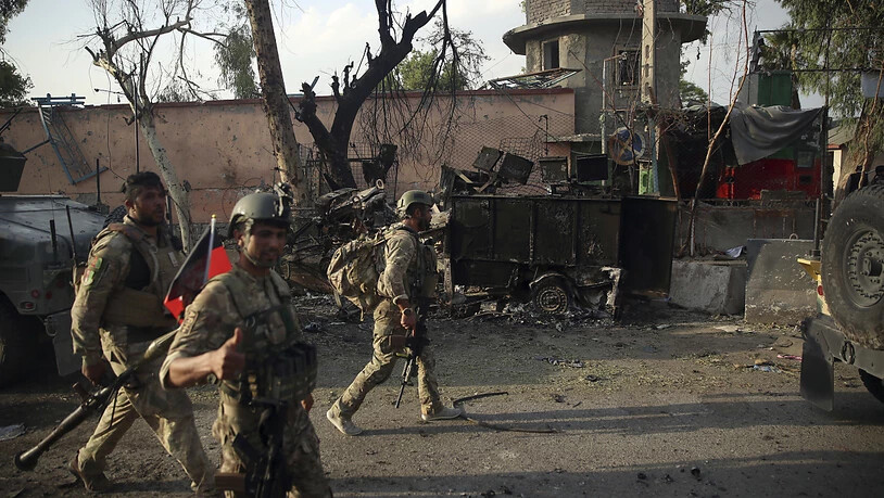 ARCHIV - Afghanische Sicherheitskräfte versammeln sich nach einem Angriff vor einem Gefängnis in Dschalalabad. Foto: Rahmat Gul/AP/dpa