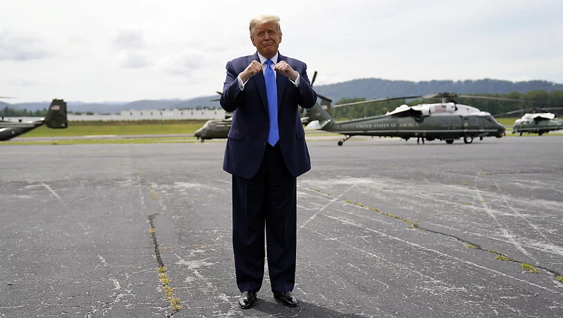 Donald Trump (l), Präsident der USA, gestikuliert nach seiner Ankunft am Flughafen Asheville. Foto: Evan Vucci/AP/dpa