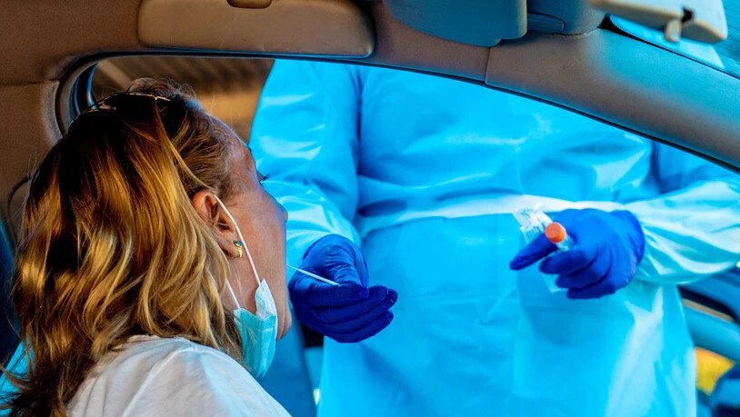 Ein Mitarbeiter des Gesundheitswesens nimmt bei einer Frau einen Abstrich in einer Drive-in Covid-19-Teststation in Sevilla. Foto: Eduardo Briones/EUROPA PRESS/dpa