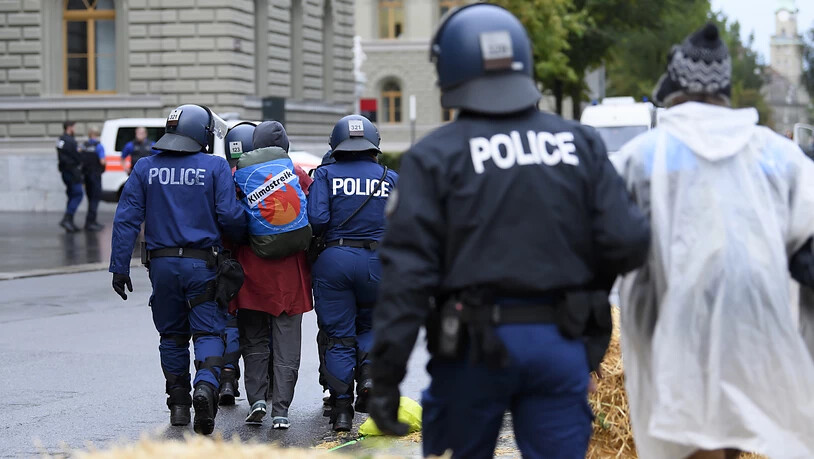 Polizisten führen Klima-Aktivisten vom Bundesplatz.