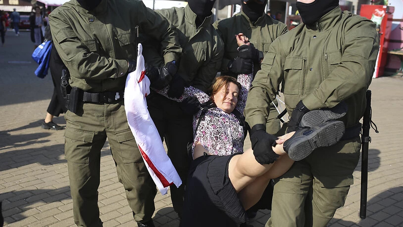Polizisten tragen am Rande einer Demonstration in Minsk eine Frau weg. Foto: Uncredited/TUT.by/dpa