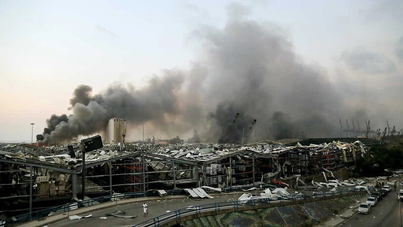 ARCHIV - Rauch steigt nach einer Explosion über einem Gebäude am Hafen auf. Mehr als vier Monate nach der verheerenden Explosion im Hafen von Beirut hat ein libanesischer Ermittlungsrichter Anklage gegen den amtierenden Regierungschef Diab und drei…