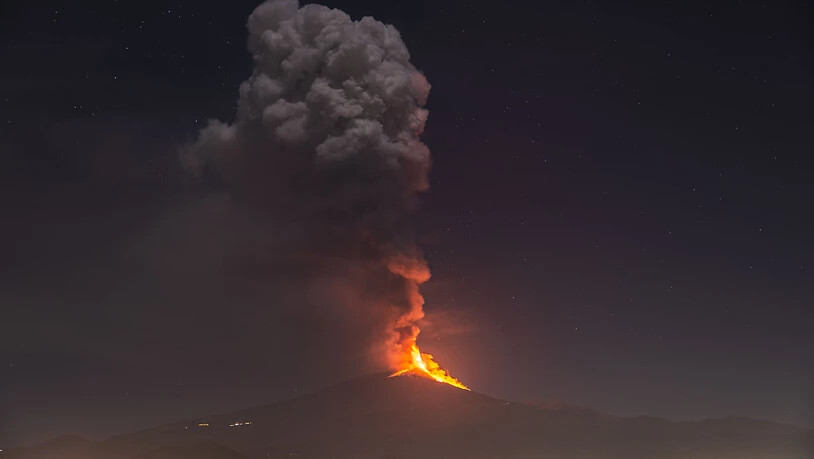 Flammen und Rauch steigen aus dem Vulkans Ätna auf und überragen die Stadt Pedara auf Sizilien. Foto: Salvatore Allegra/AP/dpa
