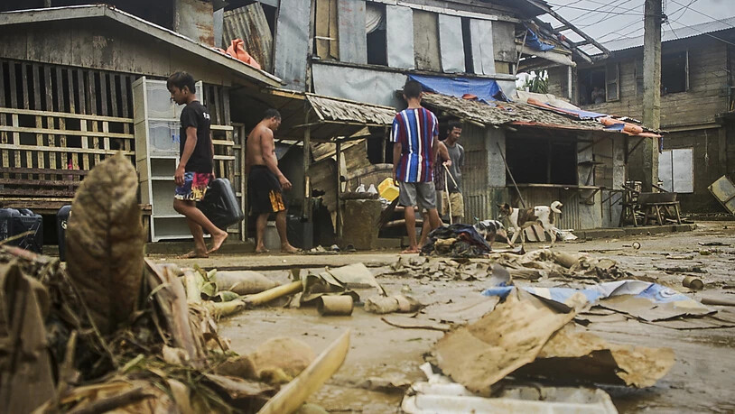 Anwohner räumen Trümmer von den Überschwemmungen durch den Taifun "Surigae" auf. Foto: Uncredited/AP/dpa