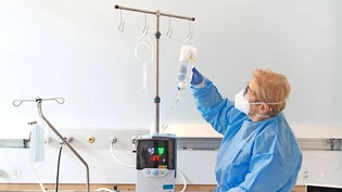 Kontrollcheck: Fachfrau Gesundheit Ewa Grabczynska, kontrolliert die Apparaturen in einem Isolationszimmer bei Patient Herrn D, der an ein sogenanntes High-Flow-Atemgerät angeschlossen ist.