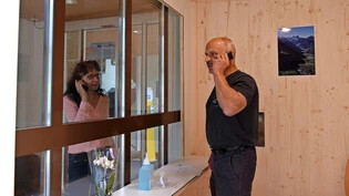 Nah trotz Corona: Peter Burlet und Heim-Co-Leiterin Steffi Bernecker demonstrieren, wie die Besucherbox funktioniert.