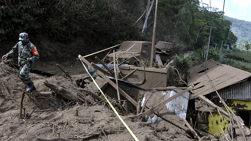 Ein indonesischer Soldat geht an Häusern vorbei, die durch einen von einem Erdbeben ausgelösten Erdrutsch in Bangli auf der Insel Bali beschädigt wurden. Foto: Dewa Raka/AP/dpa