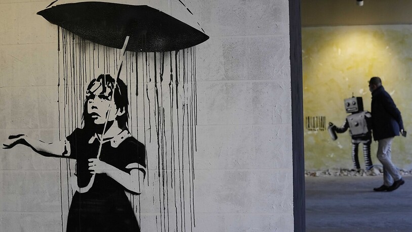 «The Umbrella girl», eine Reproduktion eines Wandgemäldes des britischen Künstlers Banksy. Foto: Luca Bruno/AP/dpa - ACHTUNG: Nur zur redaktionellen Verwendung und nur mit vollständiger Nennung des vorstehenden Credits