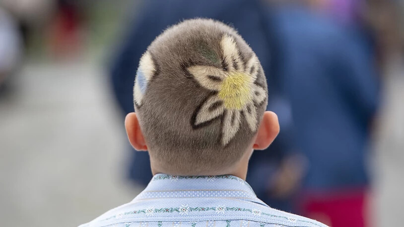 Ein Jungschwinger präsentiert seinen Enzian-Haarschnitt beim Festumzug.