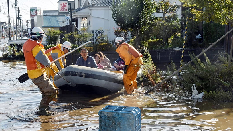 Rettungskräfte helfen Betroffenen in einem überschwemmten Wohngebiet in der japanischen Region Fukushima.