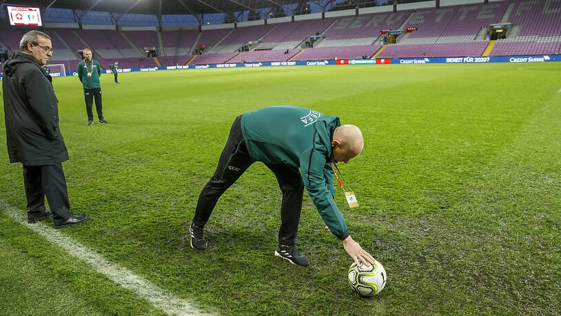 Schiedsrichter Szymon Marciniak inspiziert den durchnässten Platz im Stade de Genève und gibt grünes Licht für den Anpfiff um 20.45 Uhr