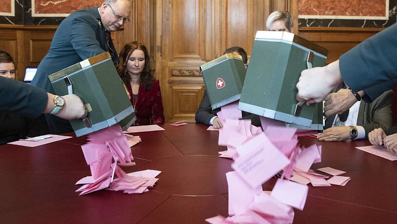 Weibel leeren bei den Stimmenzählern die Urnen mit den Wahlzetteln für die Bundesratswahlen aus.(KEYSTONE/Peter Klaunzer)