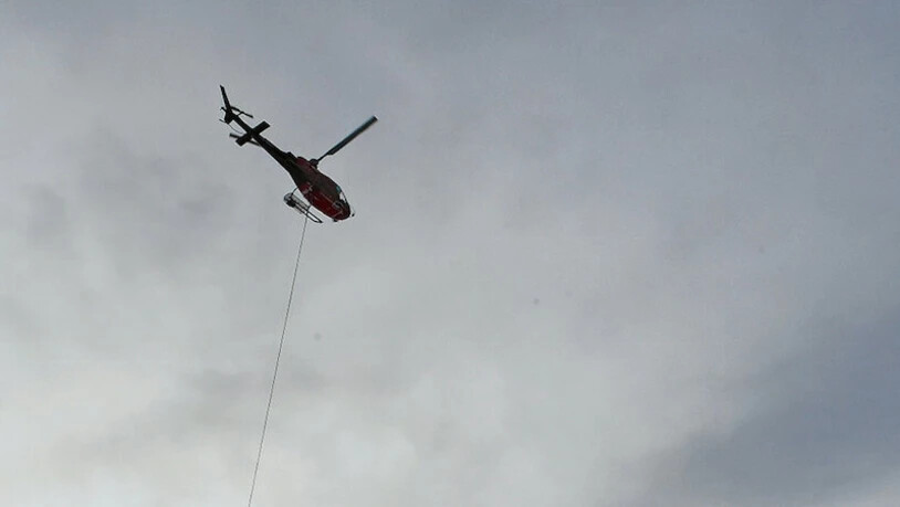 Für die Umweltverbände nicht zukunftsträchtig: Ein Helikopter fliegt eine Schneekanone ins Skigebiet von Elm.