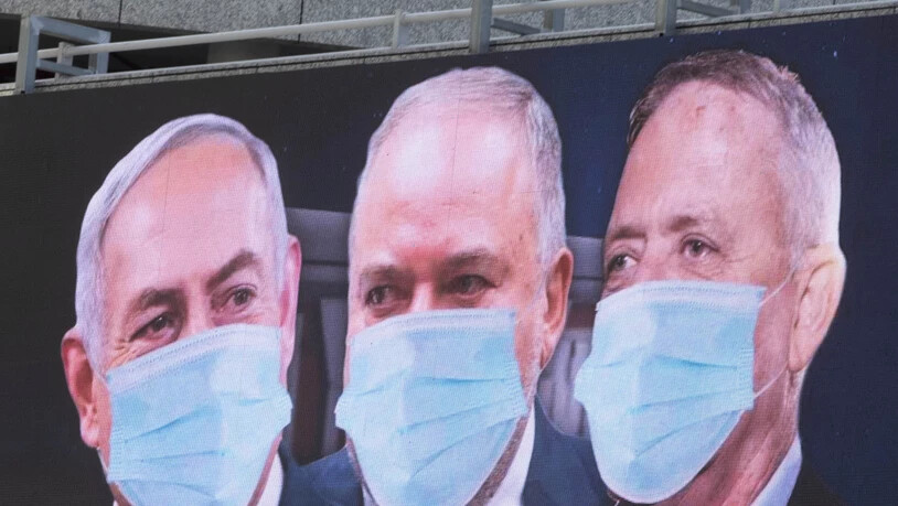 Grosse Qualition in Israel: Premierminister Benjamin Netanjahu, Rechtsaussen Avigdor Lieberman und Oppositionsführer Benny Gantz (von links) mit Mundschutz auf einem Plakat in Tel Aviv.