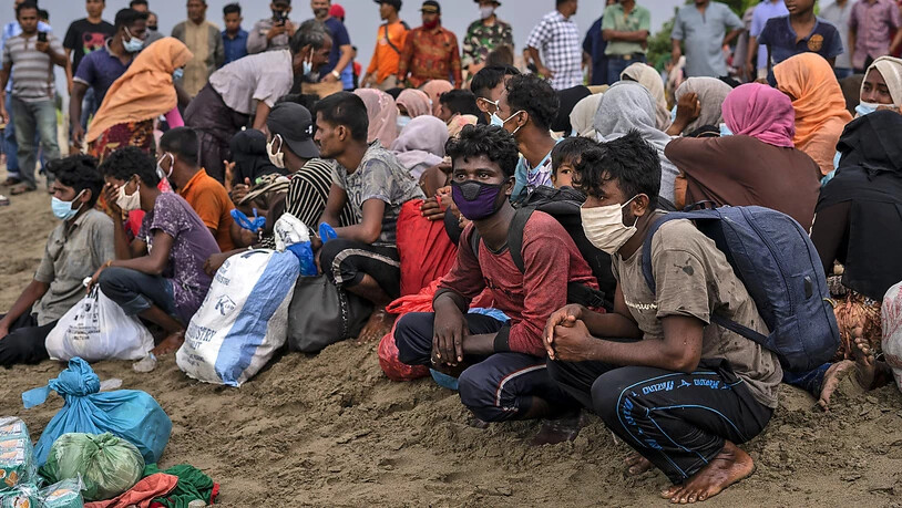 Geflüchtete Rohingya sitzen am Strand der Provinz Lancok, nachdem sie mit einem Boot dort angekommen sind. Indonesische Fischer entdeckten die hungernden und geschwächten Rohingya-Muslime auf dem Holzboot, das vor Indonesiens nördlichster Provinz Aceh…