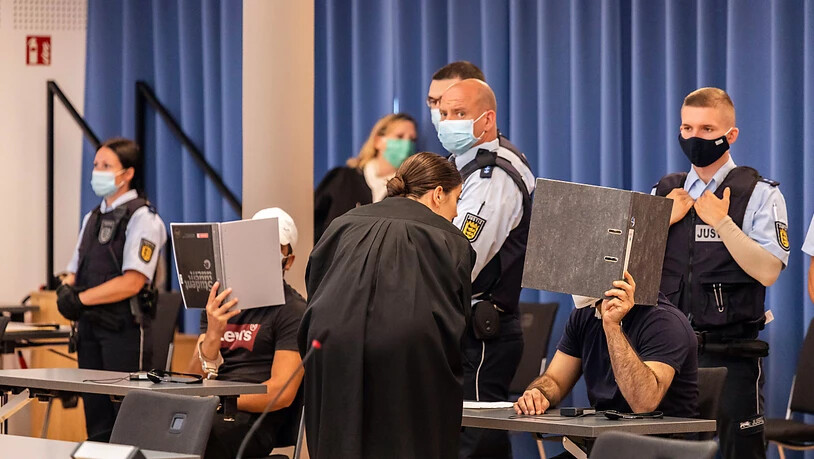 dpatopbilder - Zwei Angeklagte halten während des Prozesses in Freiburg Mappen als Sichtschutz vor ihre Gesichter. Foto: Philipp von Ditfurth/dpa - ACHTUNG: Person(en) wurde(n) aus rechtlichen Gründen gepixelt