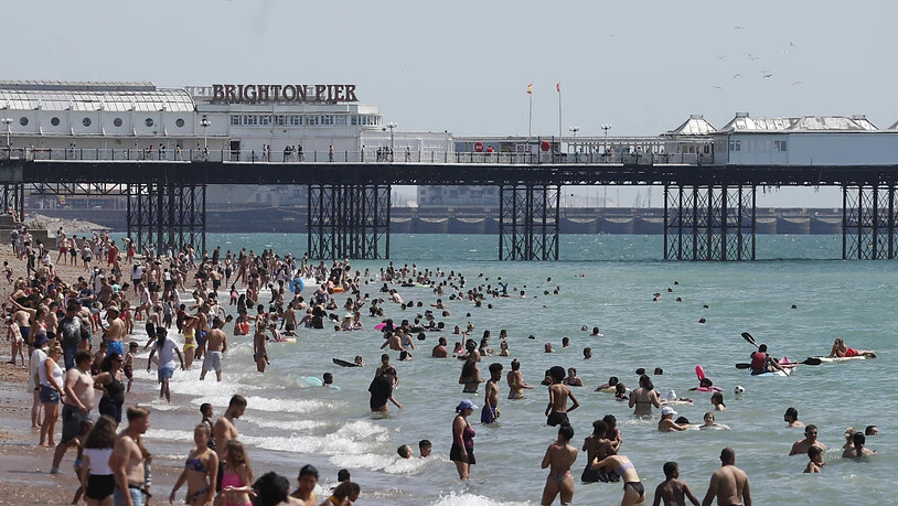 Menschen strömen bei schönem Wetter in Massen an den Strand von Brighton. Foto: Alastair Grant/AP/dpa
