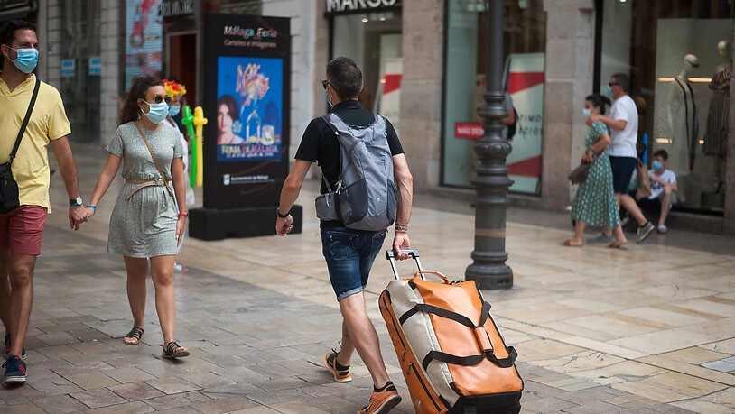 Ein Tourist trägt seine Taschen durch die Straße Marques de Larios in Malaga. Foto: Jesus Merida/SOPA Images via ZUMA Wire/dpa