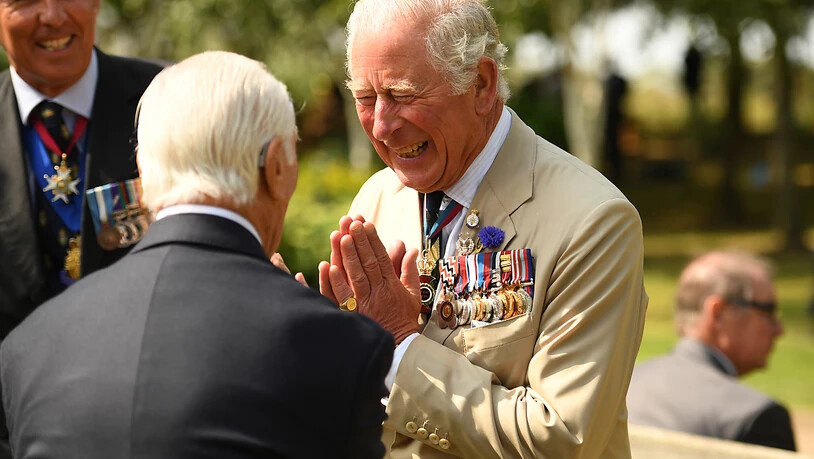 Prinz Charles (r), Prinz von Wales, begrüßt anlässlich des Tages der Kapitulation Japans im Zweiten Weltkrieg am National Memorial Arboretum einen Veteranen. Foto: Oli Scarff/PA Wire/dpa