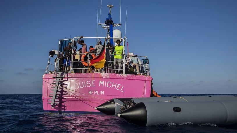 Migranten stehen an Bord des Rettungsschiffes «Louise Michel». Foto: Santi Palacios/AP/dpa
