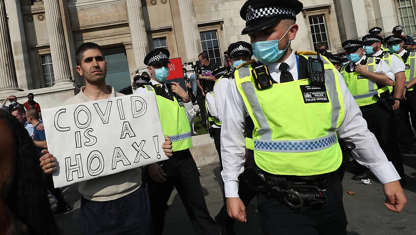 Ein Mann hält am Trafalgar Square bei einer Demonstration von Impfgegnern ein Schild mit der Aufschrift "Covid is a hoax" (Covid ist ein Schwindel) in die Höhe. Foto: Yui Mok/PA Wire/dpa