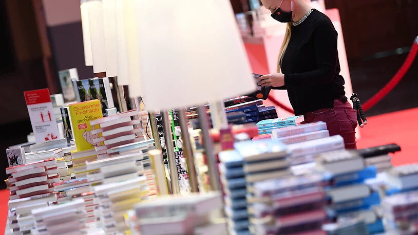 Eine Mitarbeiterin der Frankfurter Buchmesse steht vor der Eröffnungspressekonferenz der Frankfurter Buchmesse an einem Buchstand in der Festhalle. Foto: Arne Dedert/dpa pool/dpa
