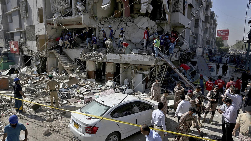 dpatopbilder - Rettungskräfte und Helfer suchen nach Überlebenden inmitten der Trümmer eines nach einer Explosion beschädigten Gebäudes. Foto: Fareed Khan/AP/dpa