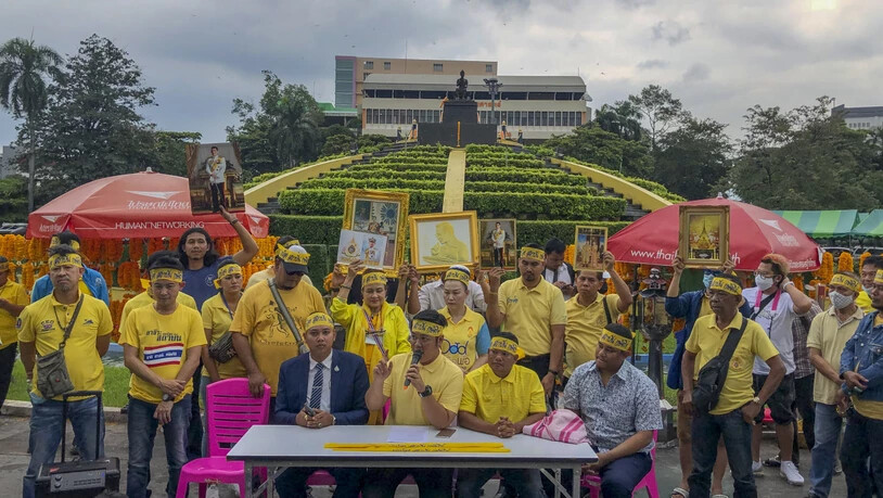 Demonstranten tragen gelbe Kleidung und halten Abbildungen des thailändischen Königs Maha und der Königin Suthida bei einem Protest vor der Ramkhamhaeng Universität, um ihre Loyalität für die Institution unter Beweis zu stellen. Foto: Peerayot…