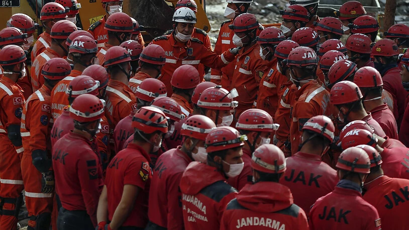 Mitglieder von Rettungsdiensten stehen für eine Lagebesprechung zusammen. Fünf Tage nach dem verheerenden Erdbeben im türkischen Izmir haben Einsatzkräfte die Rettungsarbeiten beendet. Foto: Emrah Gurel/AP/dpa