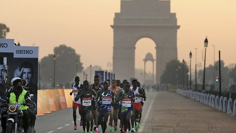Teilnehmer des Halbmarathons vor dem «India Gate» in Neu Delhi. Foto: Altaf Qadri/AP/dpa