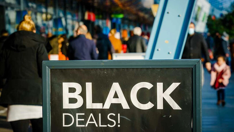 Passanten gehen vor einem Einkaufszentrum an einem Schild vorbei, das auf «Black Friday»-Angebote hinweist. Menschenmassen in Einkaufsstraßen und drohende Verstöße gegen Corona-Regeln: In den Niederlanden lehnen sich Städte gegen die Verkaufsaktion …