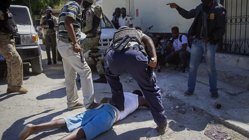 Polizisten halten einen Insassen nach einem Ausbruchsversuch aus einem Gefängnis fest. Mehrere Menschen wurden getötet, nachdem mehrere Insassen versucht hatten aus dem Gefängnis zu fliehen. Foto: Dieu Nalio Chery/AP/dpa