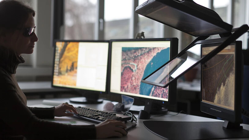 Eine Angestellte im Bundesamt für Landestopografie (swisstopo) zeichnet die Umrisse der Schweizer Seen neu. Ab März ist der Zugriff auf digitale Geodaten von swisstopo kostenlos. (Archivbild)