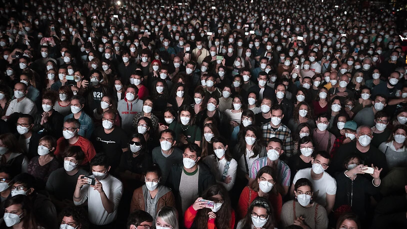 Menschen mit Mund-Nasen-Schutzbedeckung besuchen ein Konzert in Barcelona. Foto: Emilio Morenatti/AP/dpa