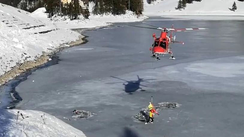 Ein Rega-Notarzt wird an der Rettungswinde ins Eisloch hinunter gelassen, um die beiden im zugefrorenen Seealpsee eingebrochenen Männer nacheinander aus dem eiskalten Wasser zu retten.