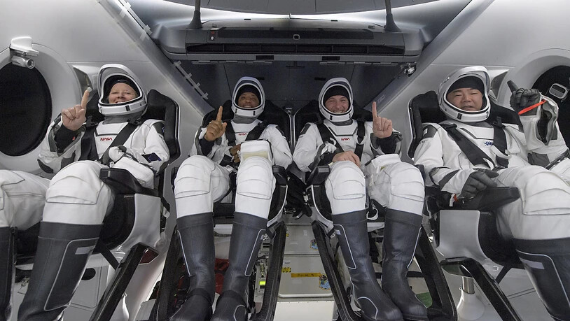 Die NASA-Astronauten Shannon Walker (l-r), Victor Glover, Mike Hopkins und der Astronaut der Japan Aerospace Exploration Agency (JAXA) Soichi Noguchi sitzen im Inneren des SpaceX Crew Dragon Resilience-Raumschiffs an Bord des SpaceX GO Navigator…