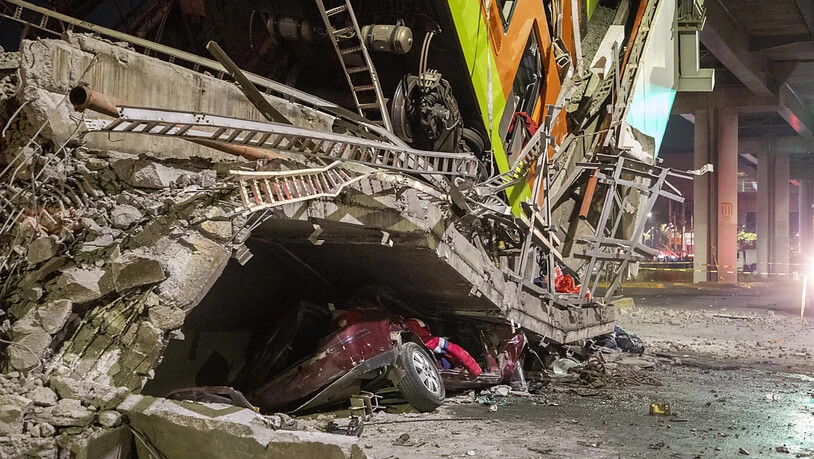 Ein Auto liegt unter Trümmern, nachdem ein Brückenabschnitt der U-Bahn-Linie 12 in Mexiko-Stadt zusammengebrochen war. Zwei Waggons stürzen auf eine viel befahrene Straße. Foto: Jair Cabrera Torres/dpa