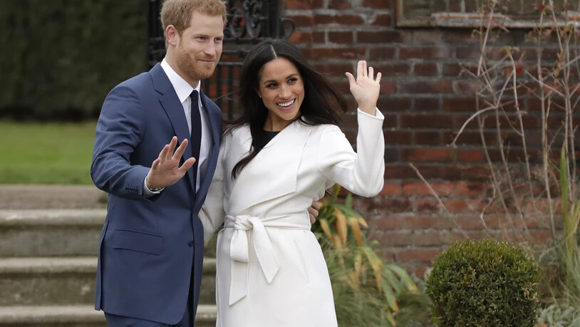 ARCHIV - Der britische Prinz Harry und die US-amerikanische Schauspielerin Meghan Markle winken nach Bekanntgabe ihrer Verlobung auf dem Gelände des Kensington Palace. Harry und Meghan sind nun zum zweiten Mal Eltern geworden. Foto: Matt Dunham/AP/dpa