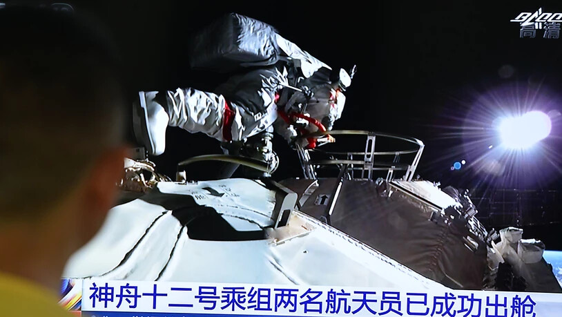 Die beiden Astronauten Liu Boming und Tang verlassen in ihren Raumanzügen die Station. Foto: Sheldon cooper/SOPA Images via ZUMA Wire/dpa